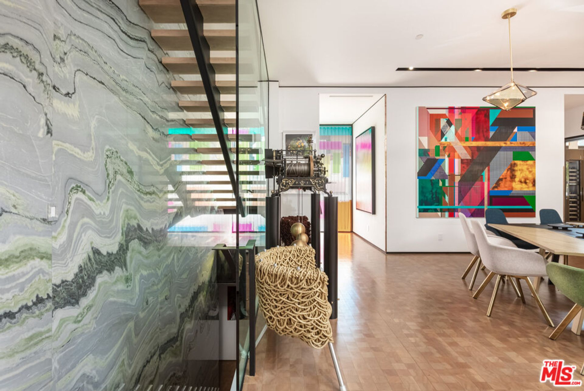 Home interior with a dramatic marble wall and contemporary artwork.