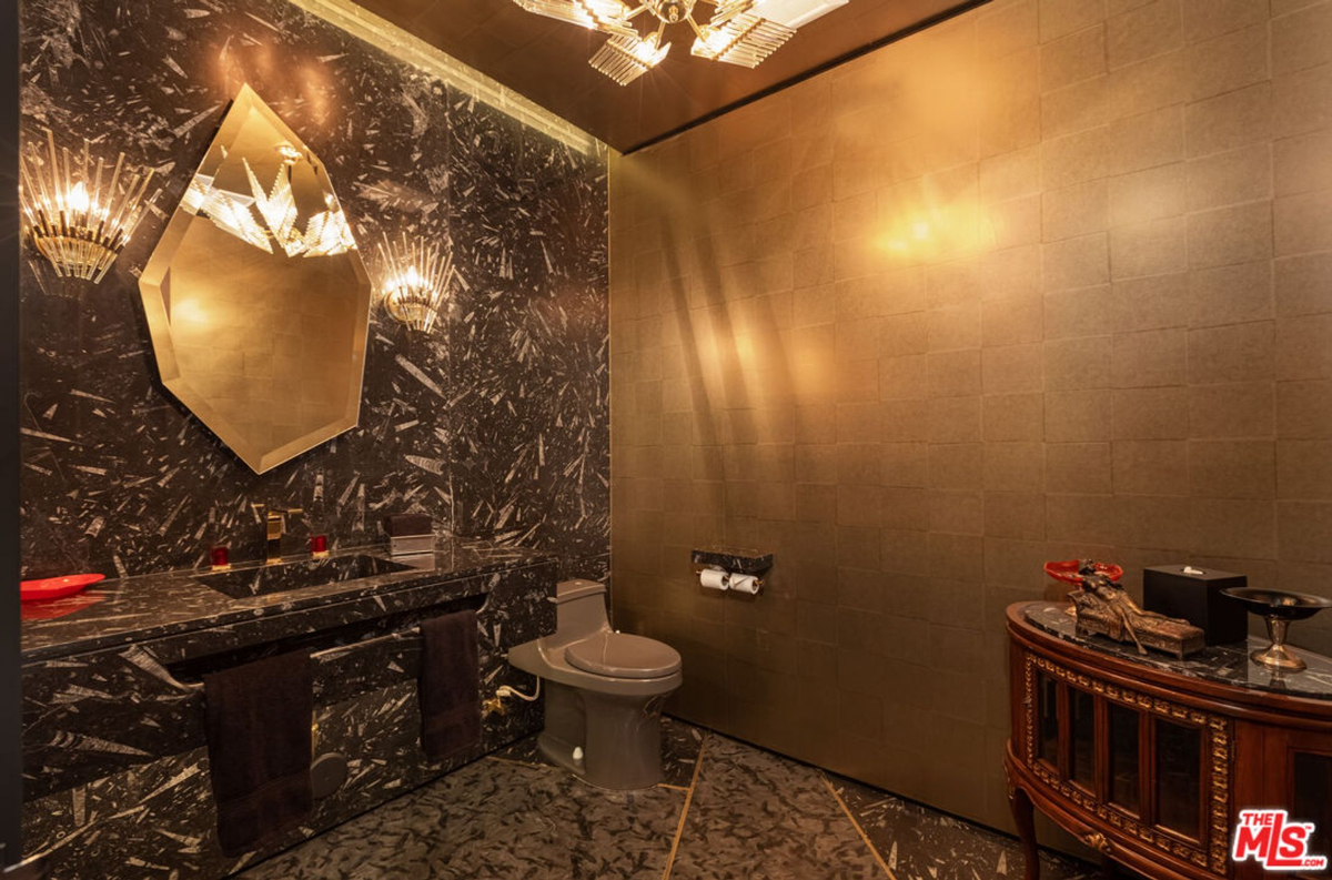 Luxury bathroom with dark marble and gold accents.