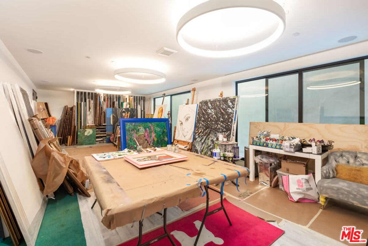 Artist's studio or workshop filled with canvases, paintings, and art supplies.