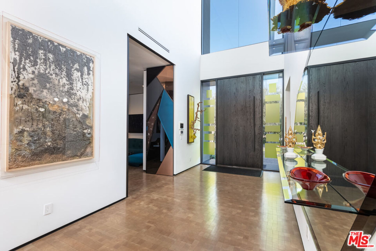 Large-scale artwork complements a minimalist entryway with expansive windows.