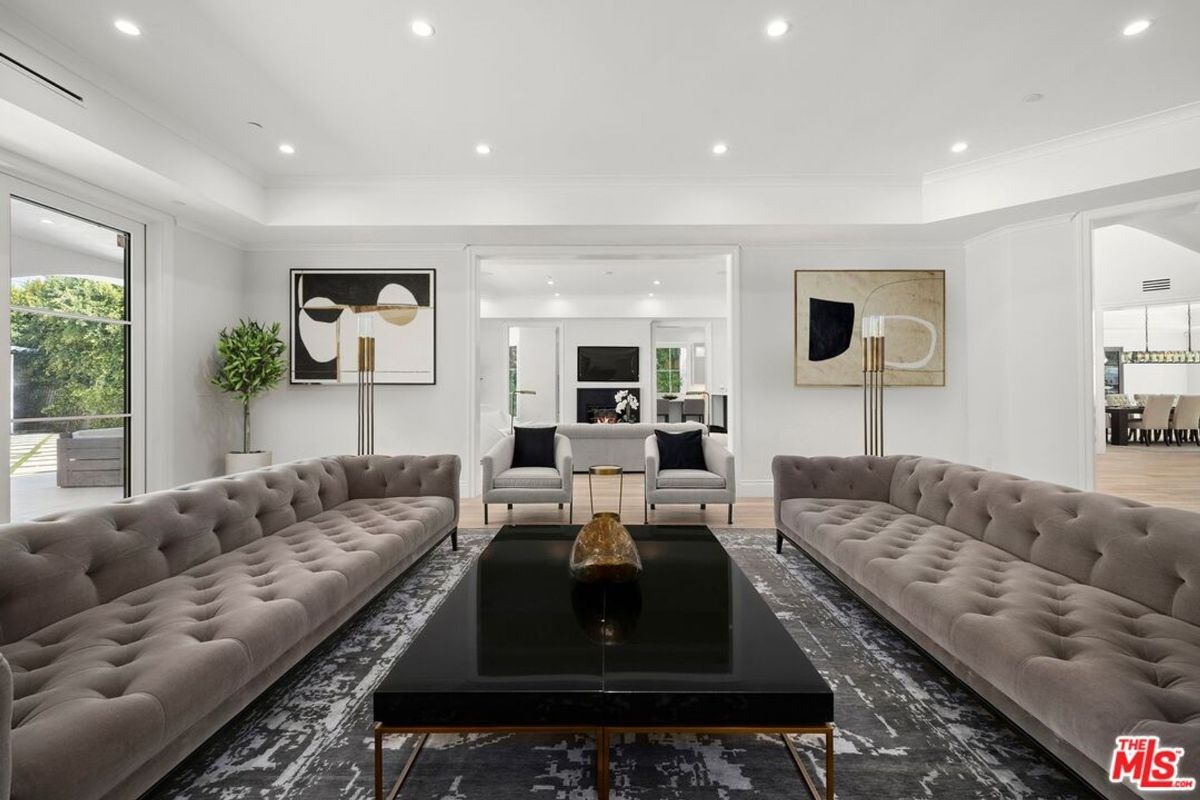 Two long, plush sofas face each other across a large, low coffee table in a spacious living room.