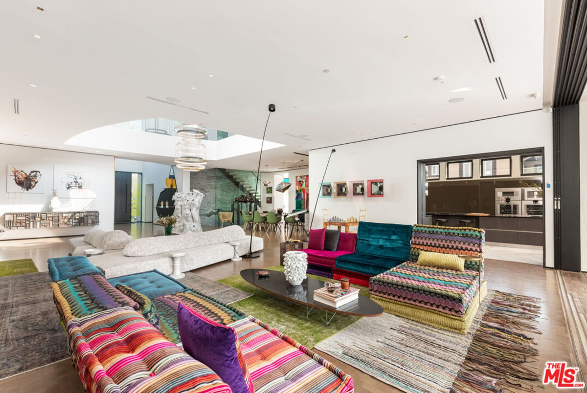 High ceilings and an open layout create a spacious and airy feel in this eclectic living room.