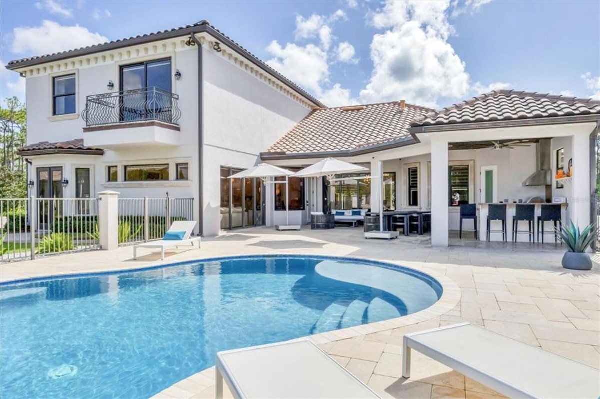 Mediterranean-style house with a swimming pool in the foreground.