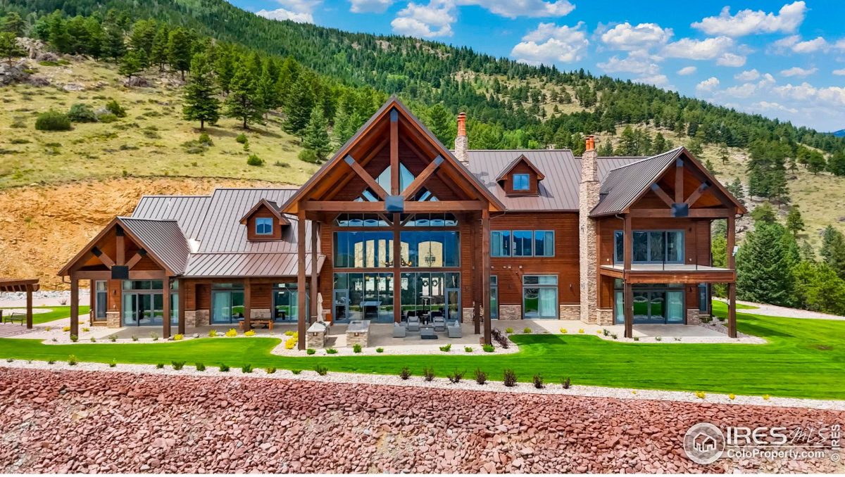 Large mountain home showcases expansive windows and a spacious outdoor area.