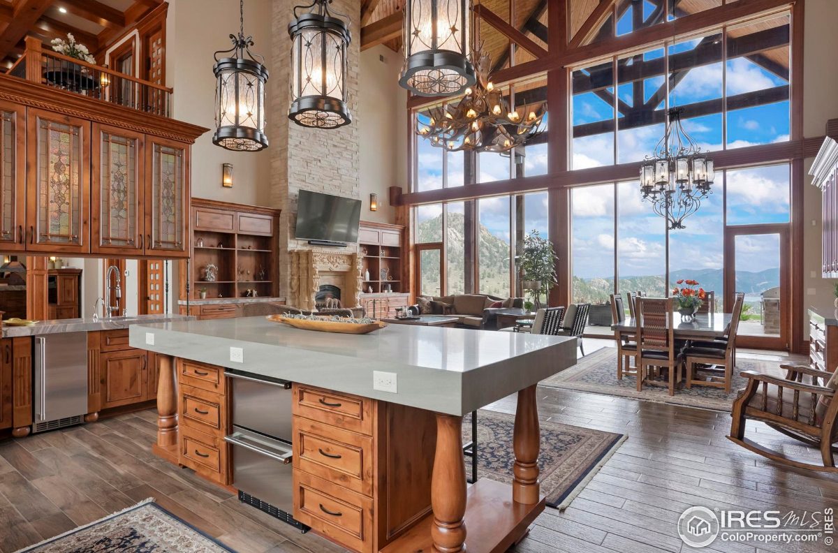 Open floor plan showcases a large kitchen island, expansive windows with mountain views, and a dining area.