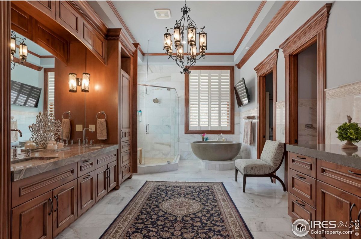 Elegant master bathroom features a double vanity with marble countertops, a freestanding tub, and a walk-in shower.