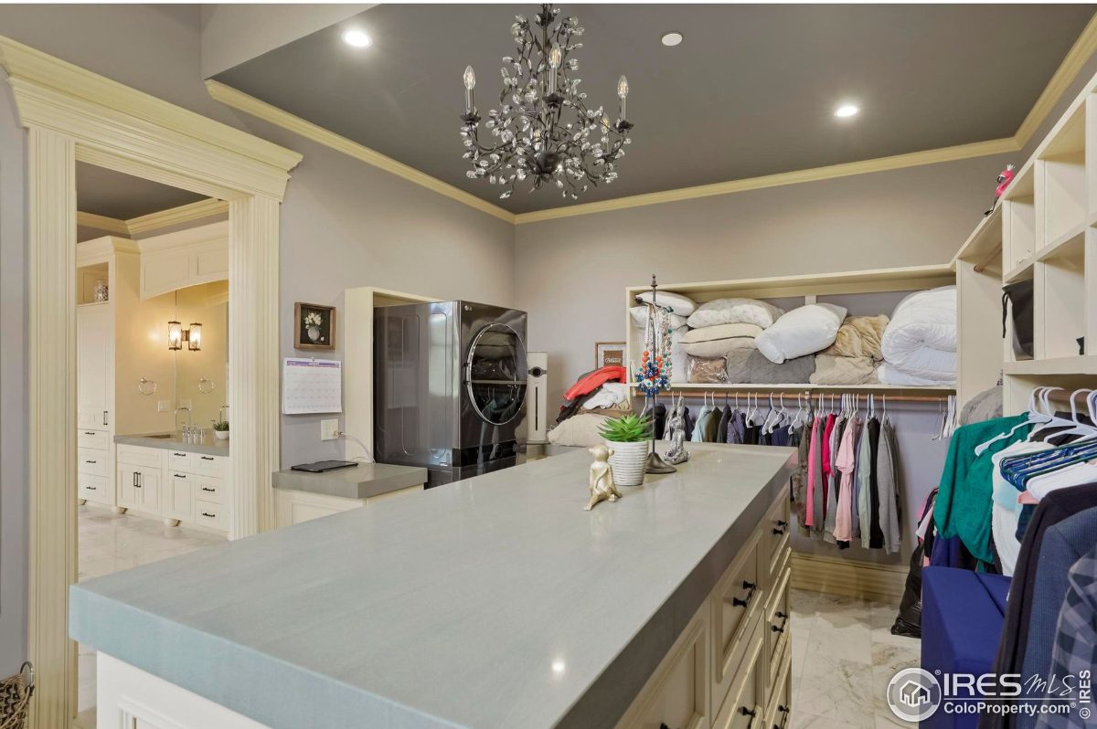 Spacious walk-in closet features ample shelving, hanging rods, and a center island.