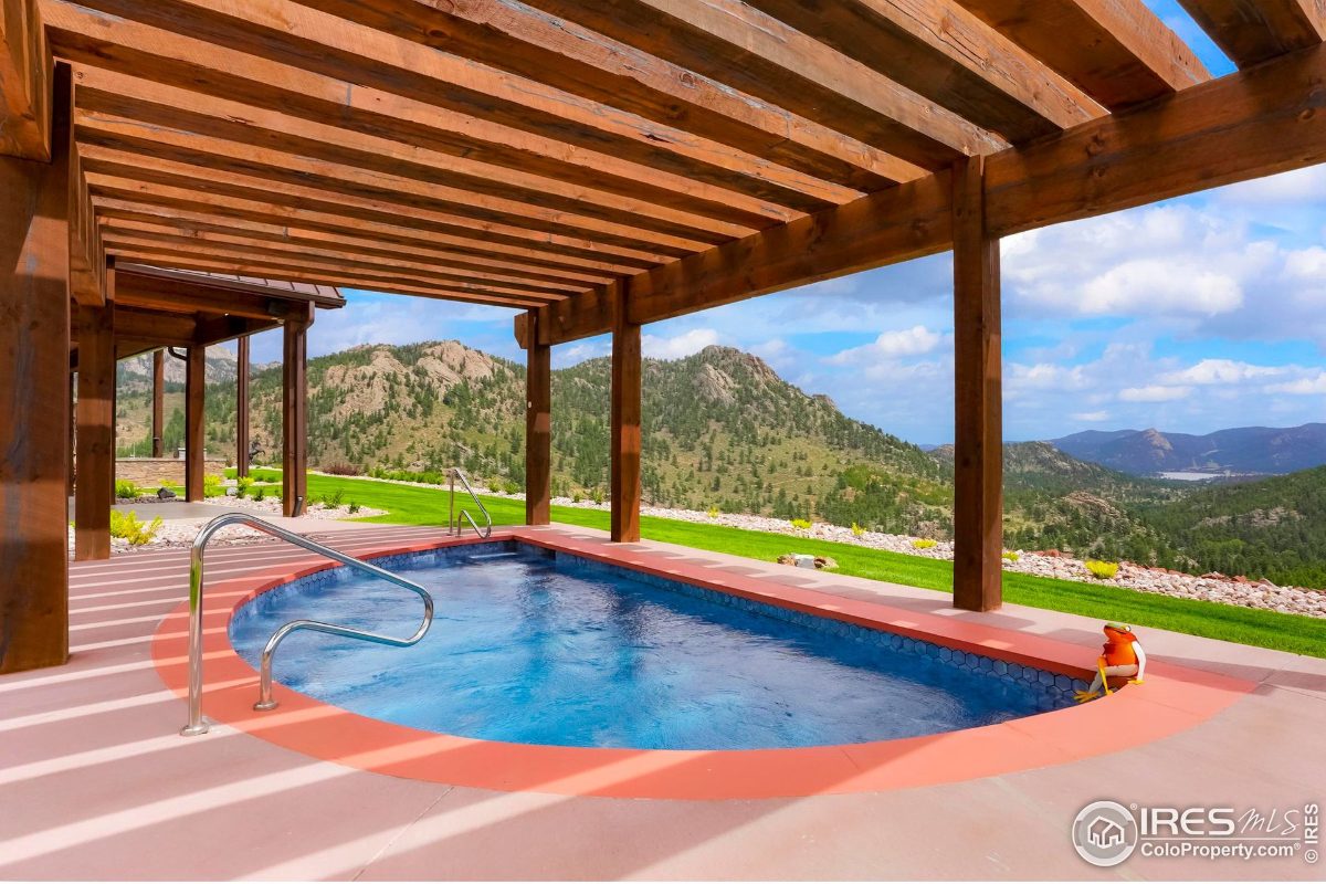 Relaxing hot tub area features a covered patio with mountain views.