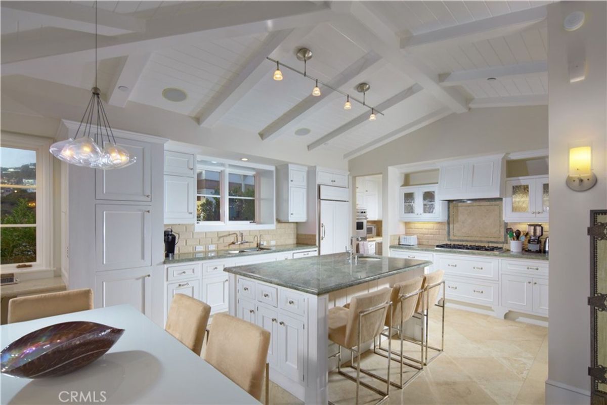 High ceilings and white cabinetry define a bright kitchen's design.