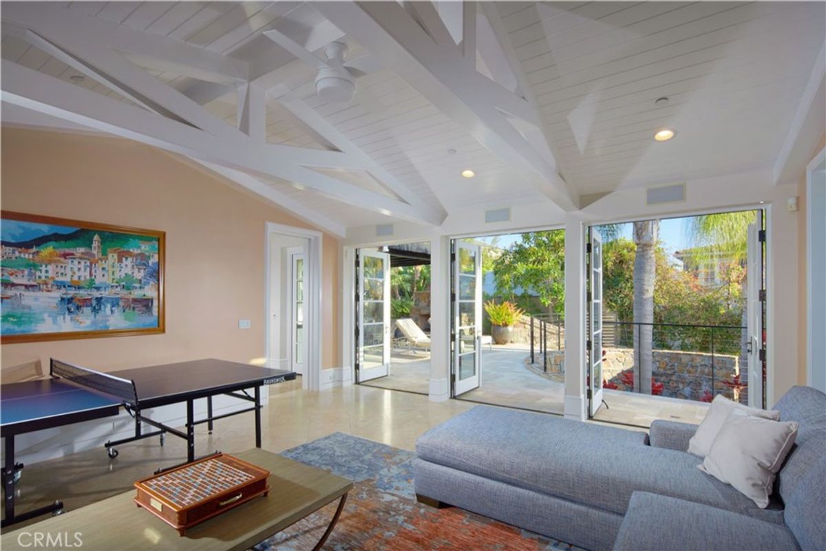 French doors open to an outdoor patio from a game room with a ping pong table.