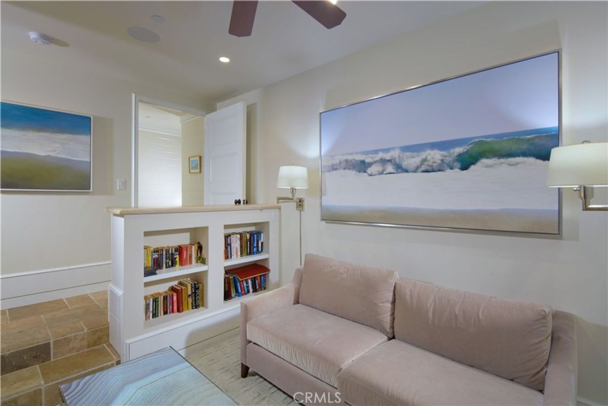 A built-in bookcase separates a seating area from another room.