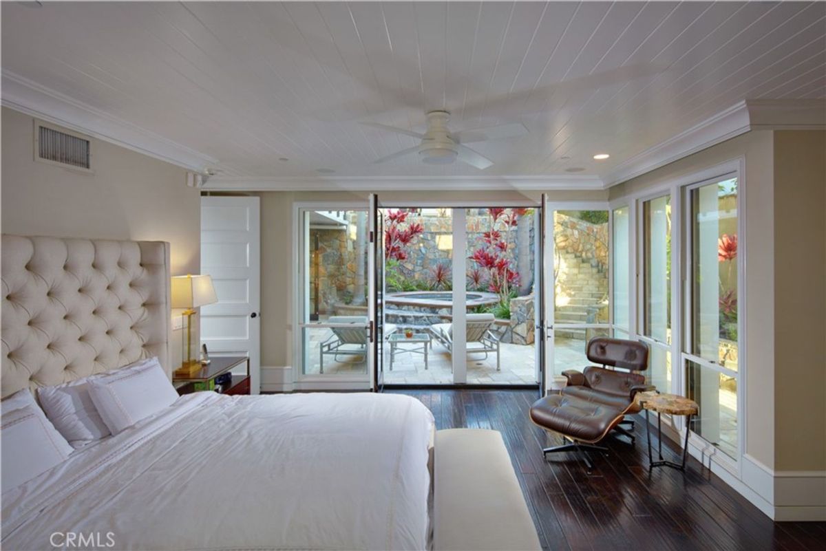 French doors open to a private patio from a master bedroom.