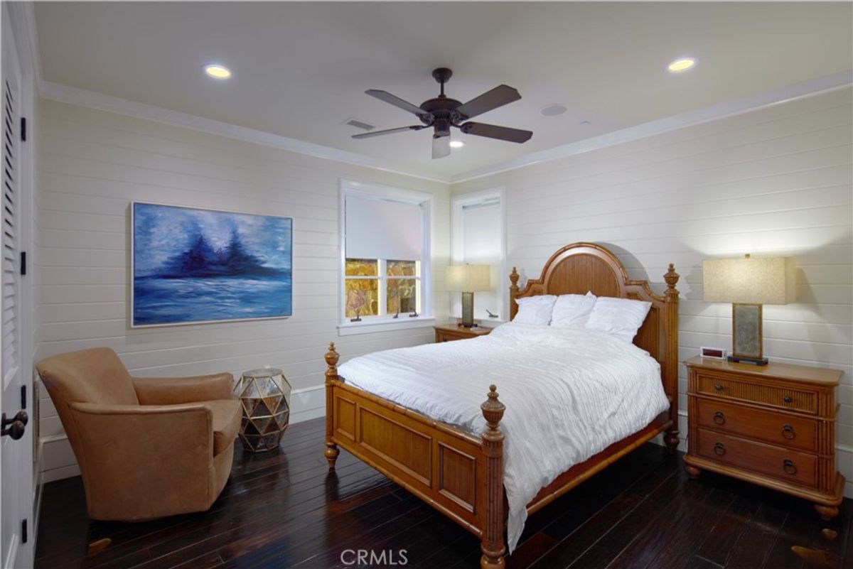 Bedroom with dark hardwood floors and a ceiling fan.