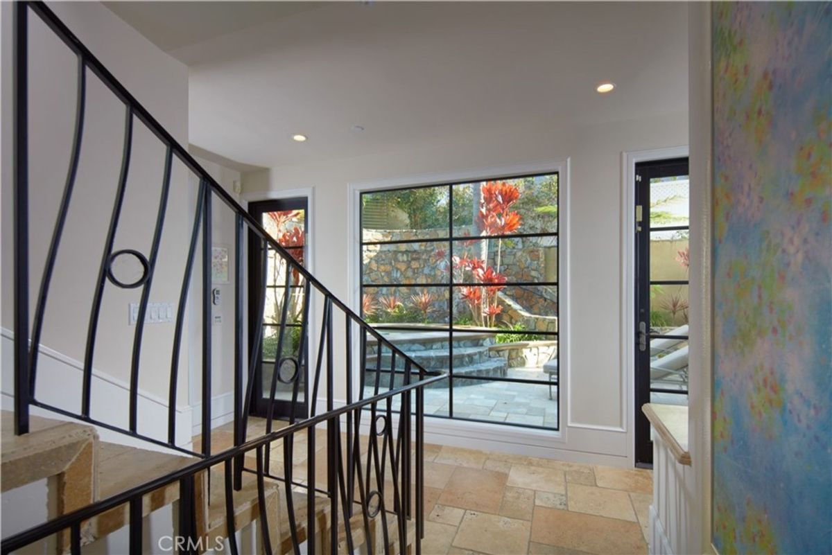 Ornate iron railings accent a staircase overlooking a courtyard.