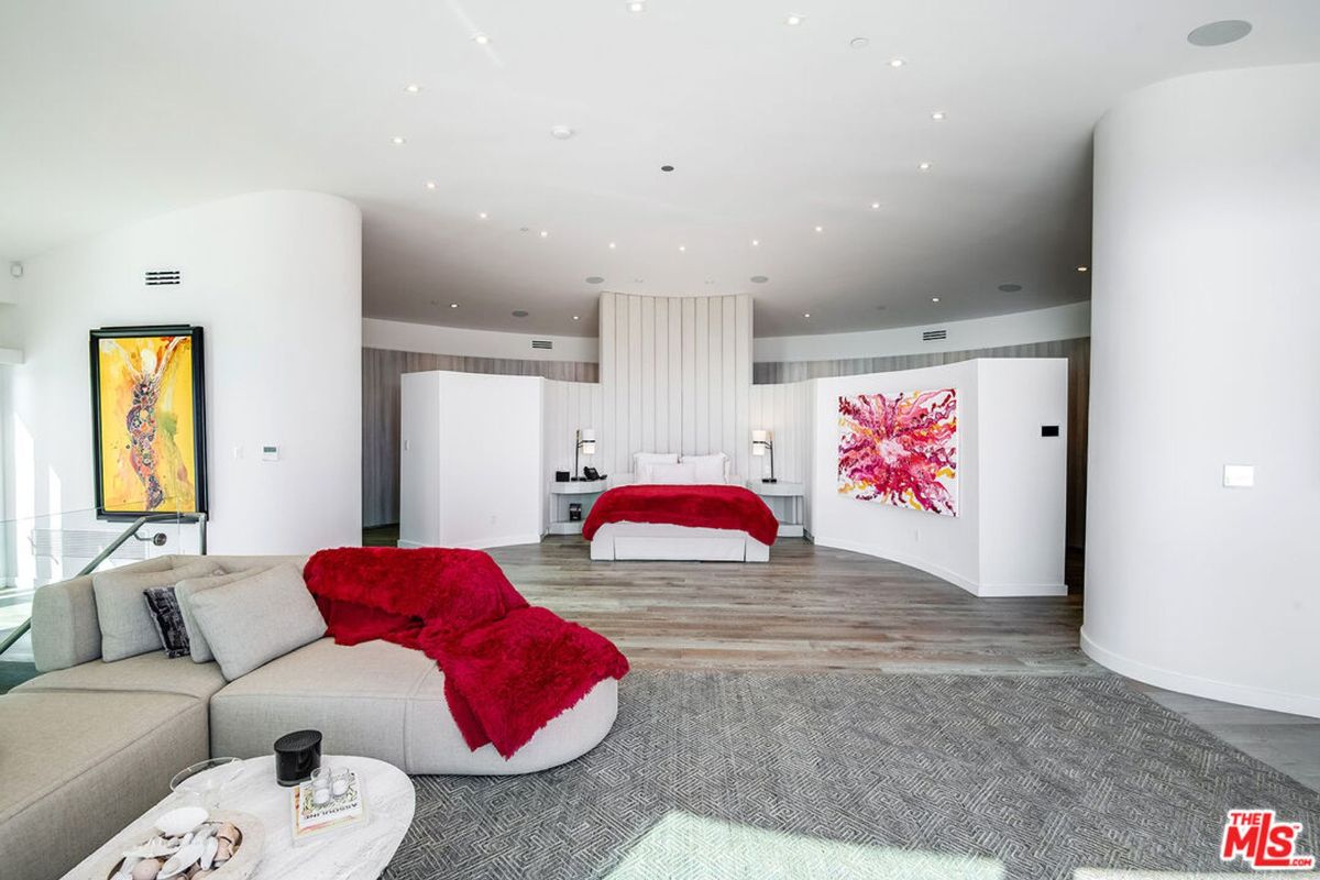 Ocean-view bedroom features floor-to-ceiling windows, a large bed, and modern decor.