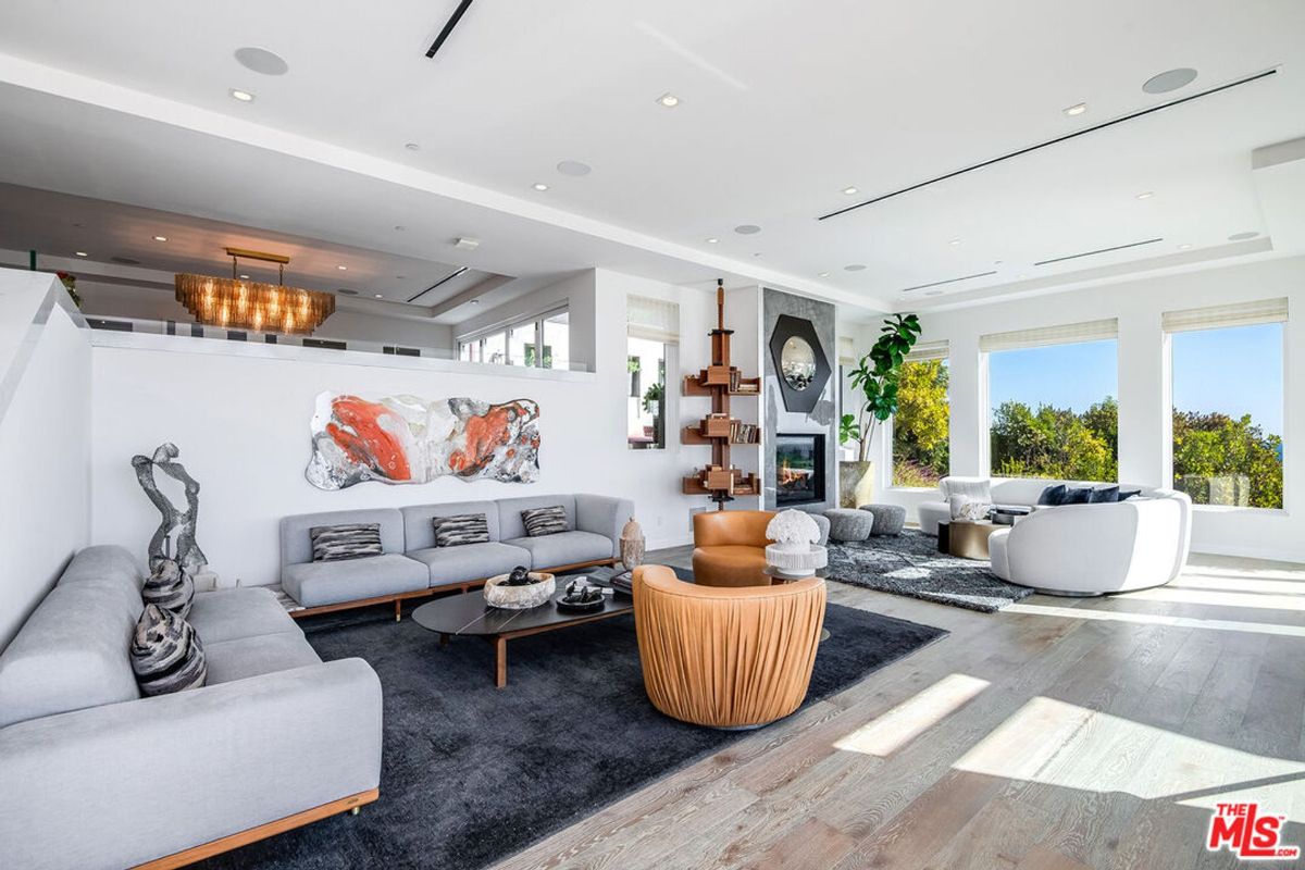 Modern living room boasts expansive windows, stylish furniture, and dramatic artwork.