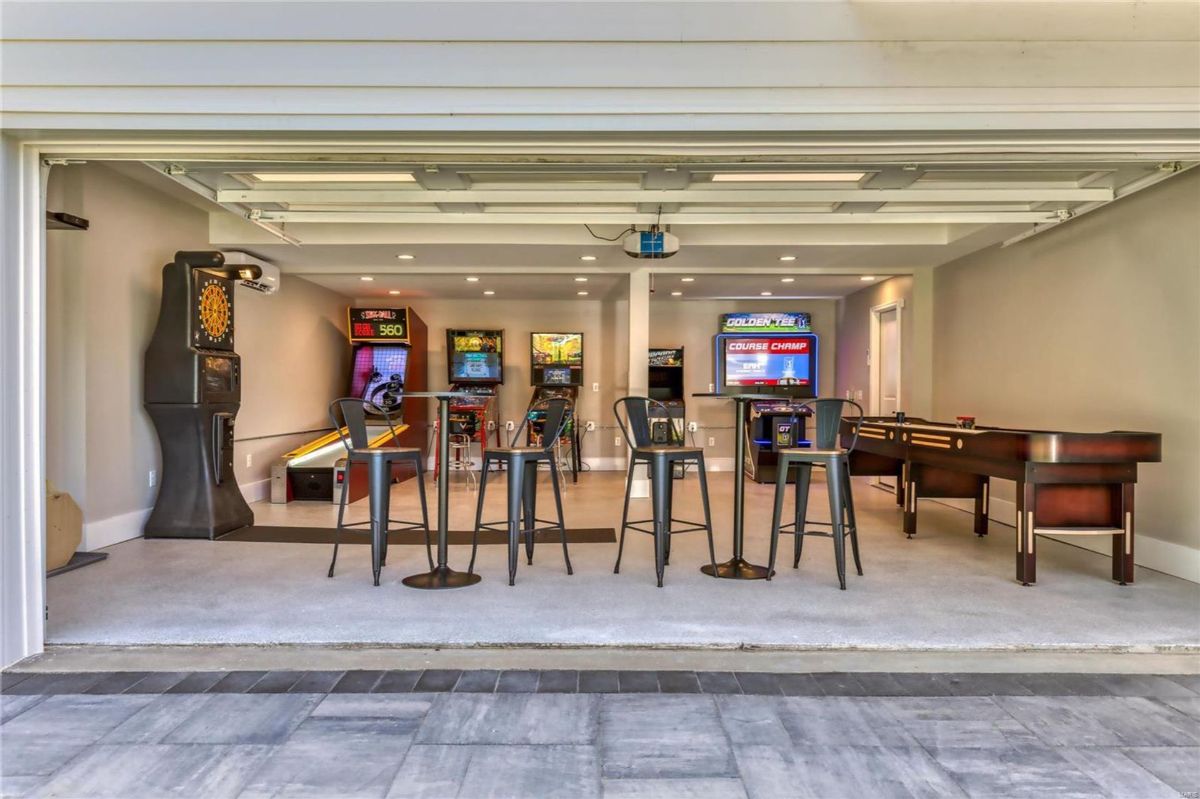 A game room features a variety of arcade games, including pinball and skee-ball, as well as a shuffleboard table. 