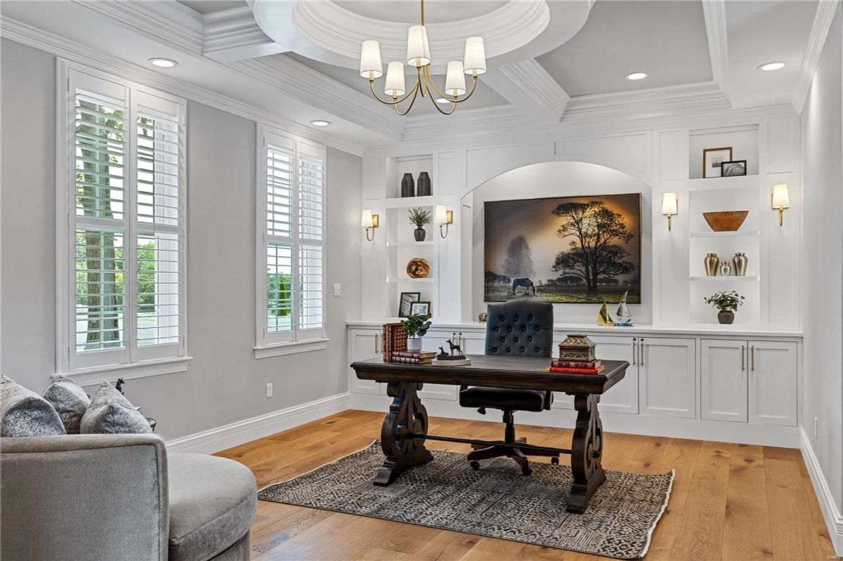 Home office features a large dark wood desk with a tufted leather chair. 