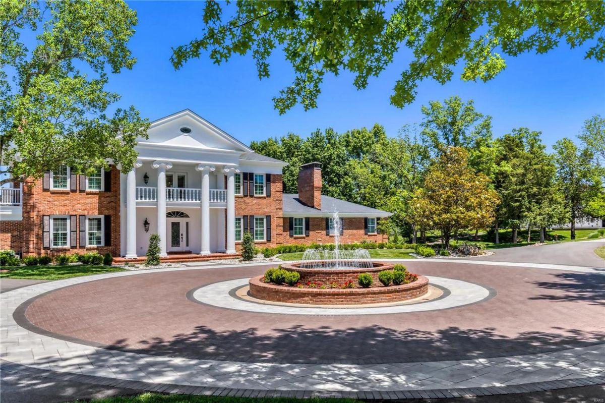 The home has a circular driveway with a fountain in the center.