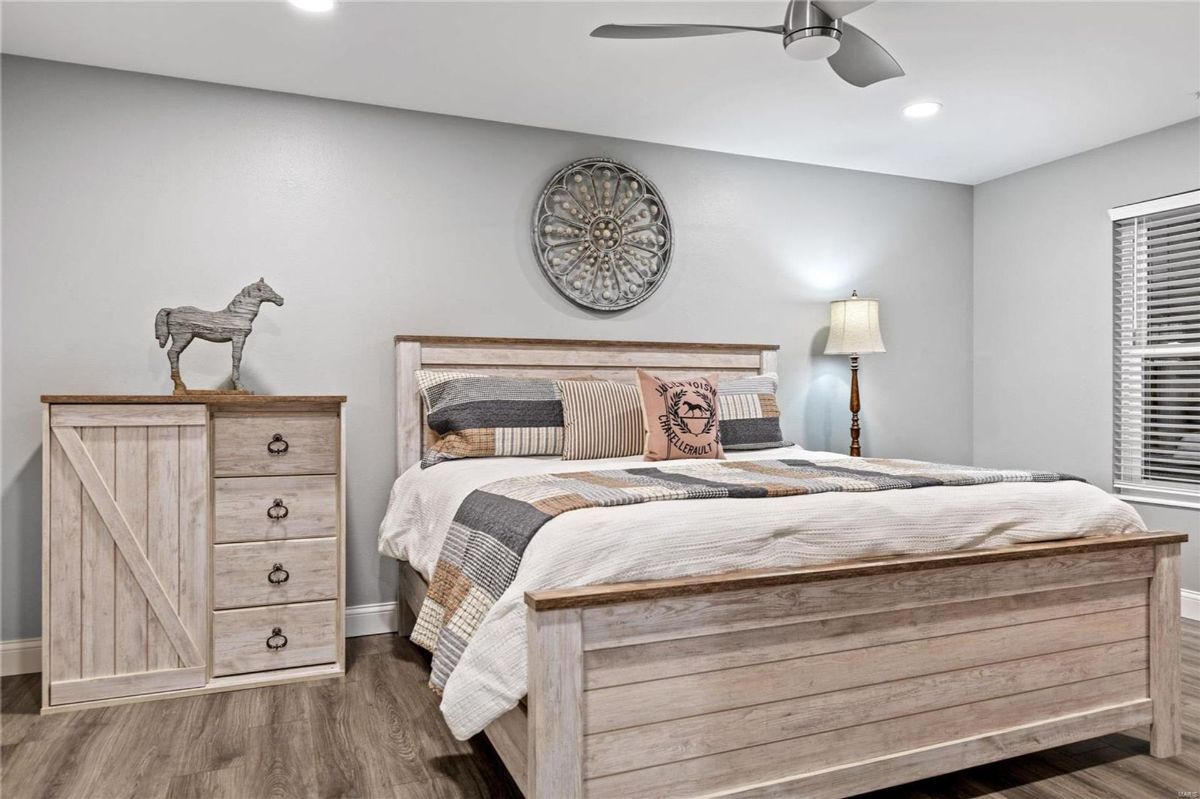 Bedroom features a light-colored wood platform bed with a neutral-toned bedding set.