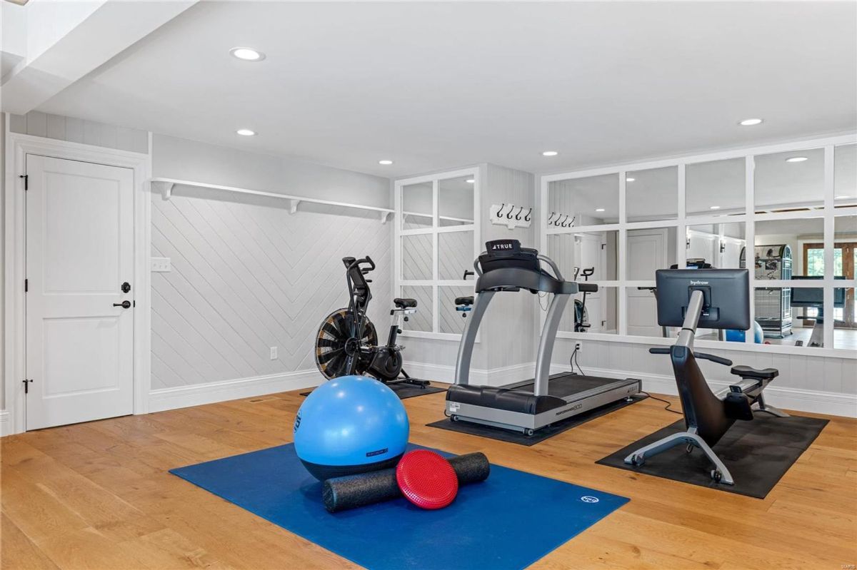 Home gym features a treadmill, stationary bike, and rowing machine.