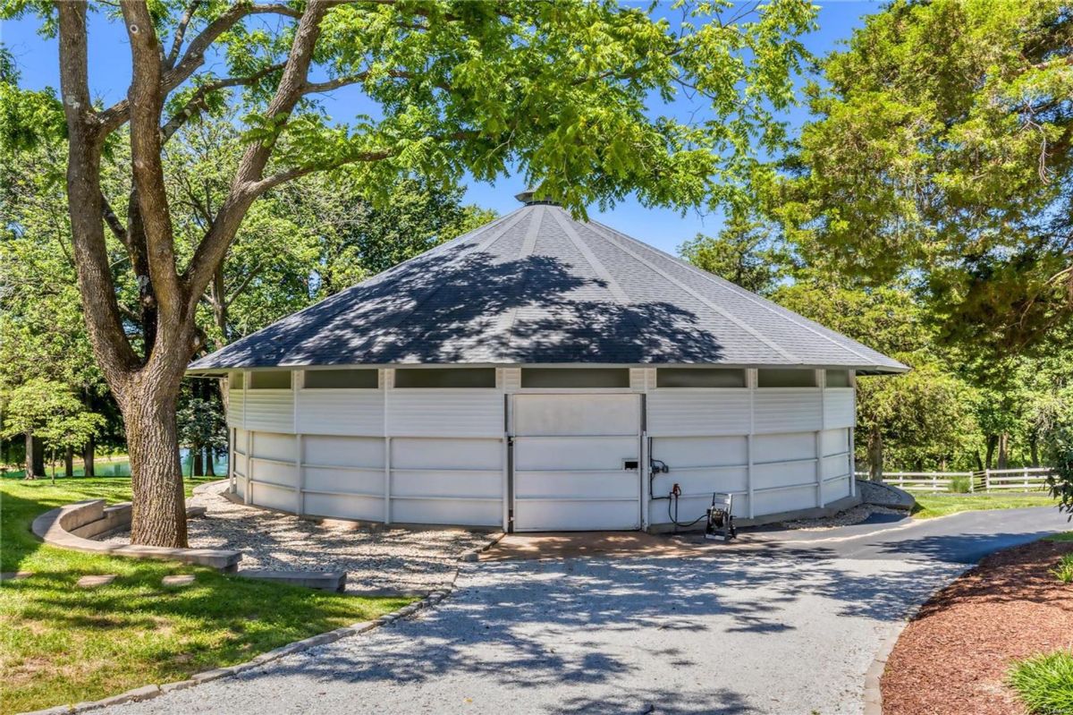 The structure appears to be a stable or similar agricultural building. A gravel driveway leads to the building.