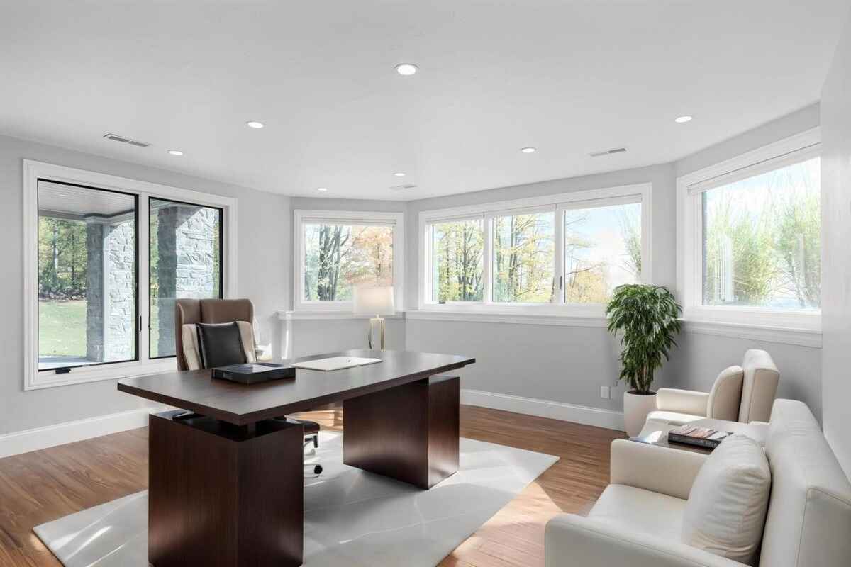 Private office space is surrounded by large windows, a central desk, and additional seating.