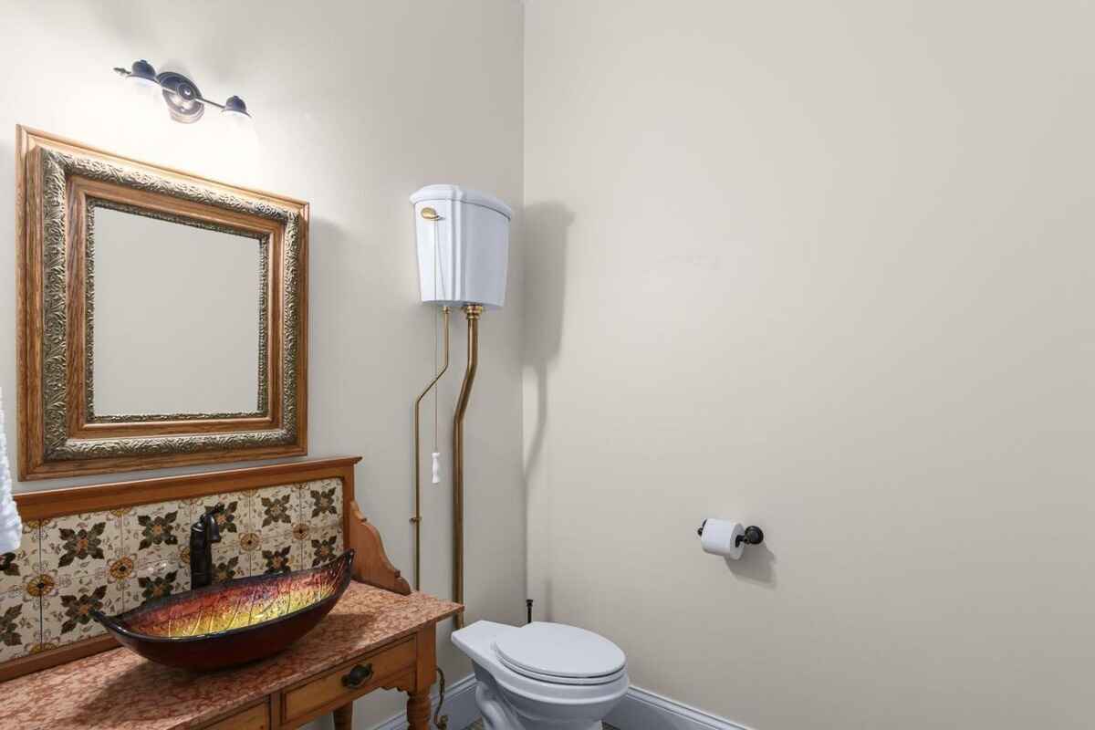 Powder room features a vintage-style sink, patterned backsplash, and decorative mirror.