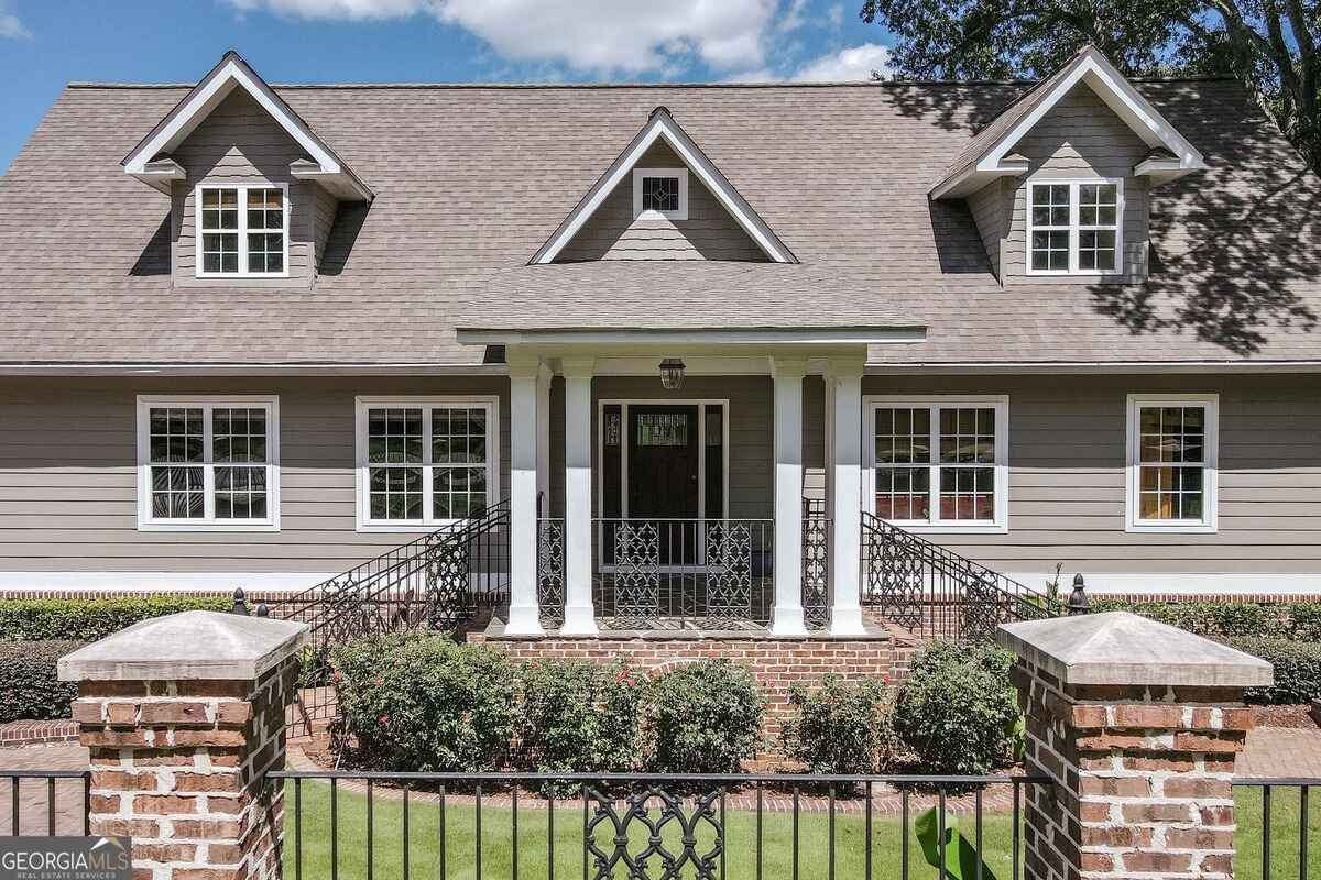 Front elevation showcases a symmetrical design with dormer windows and a welcoming front porch framed by white columns.