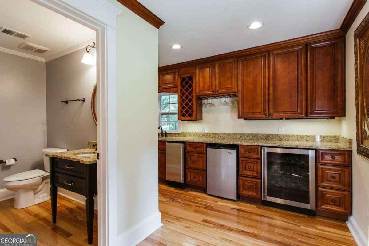 Combined bar and restroom view reveals cohesive design elements with a modern vanity.