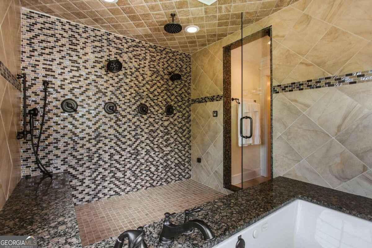 Shower room highlights intricate tilework, multiple fixtures, and a spa-like ambiance.