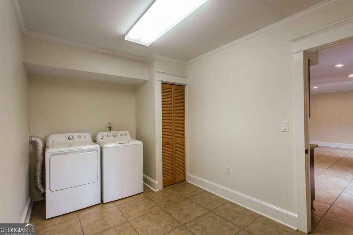 Secondary laundry or utility area is equipped with additional appliances and storage.