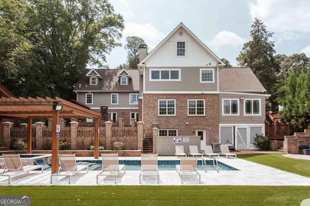 Exterior view highlights a pool area with lounge chairs and a landscaped yard.