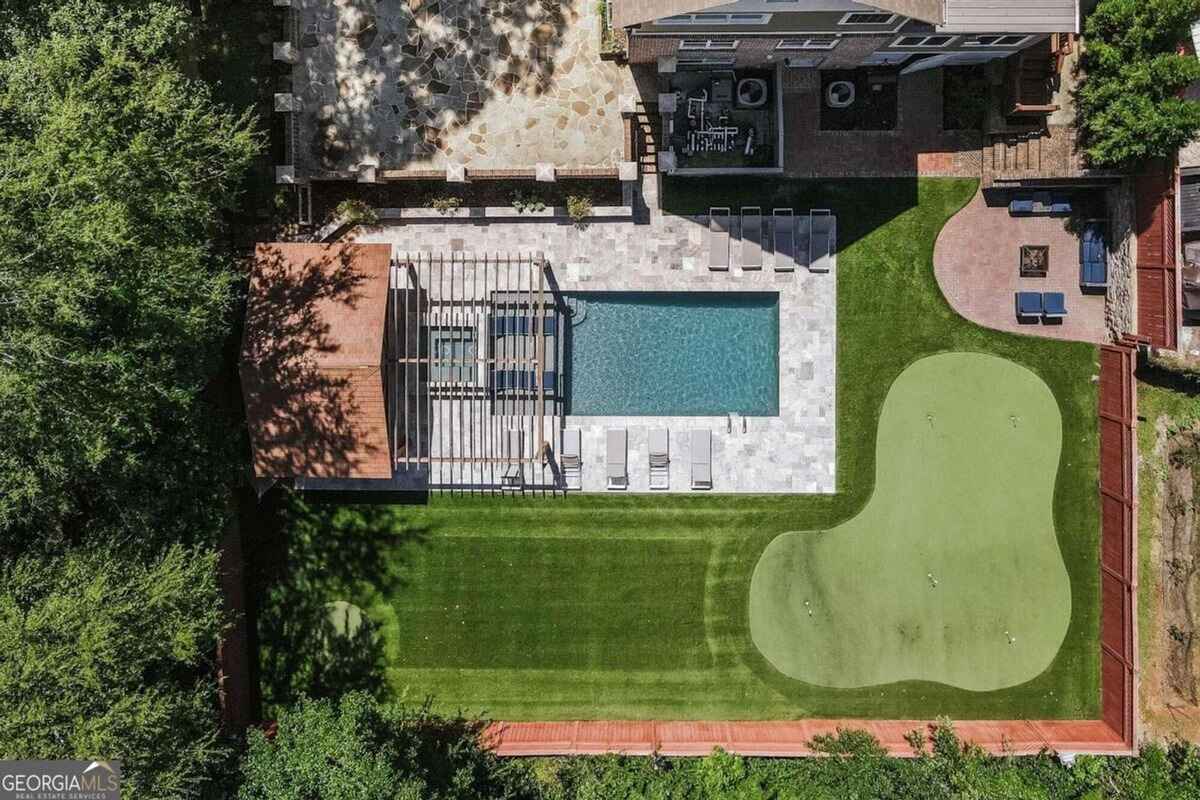 Aerial perspective reveals a swimming pool, putting green, and landscaped backyard layout.