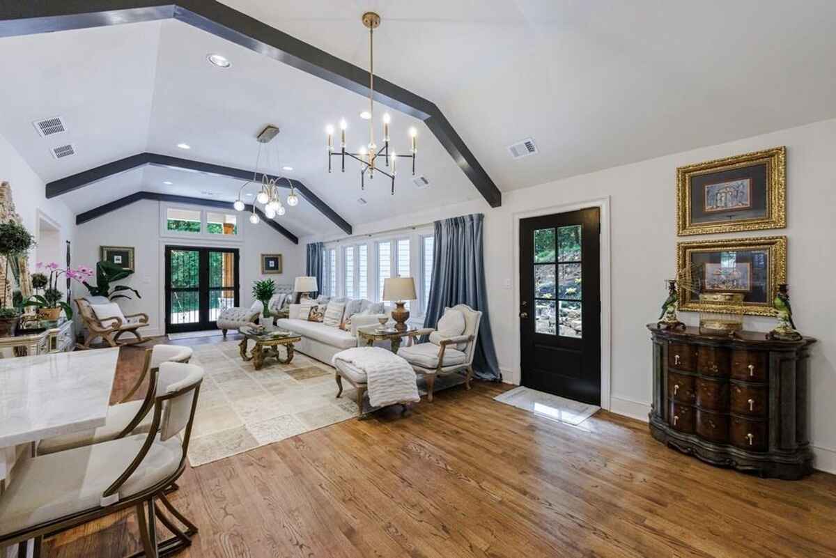 Living room highlights vaulted ceilings, large windows, and a blend of traditional and contemporary furniture.