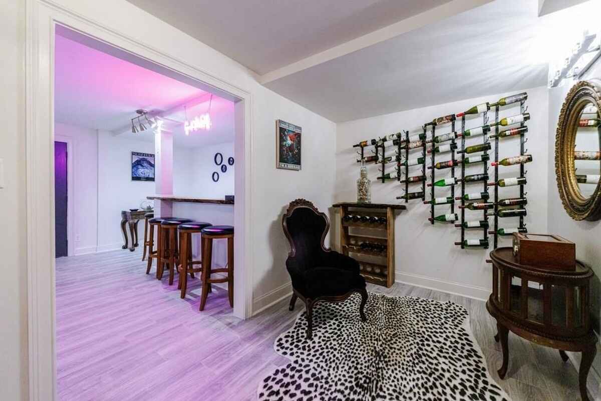 Wine racks, a bar area, and an ornate chair create a sophisticated and inviting basement lounge.