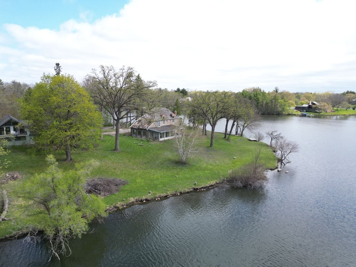 This idyllic lakeside property offers a tranquil escape, boasting a charming main house and a secondary structure nestled amidst lush greenery. The serene waterfront setting provides a picturesque backdrop for peaceful living.