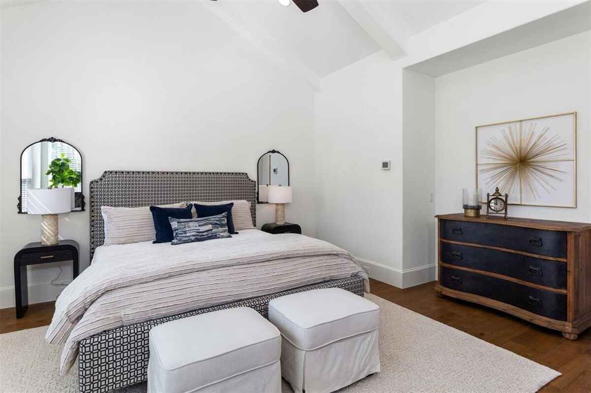 Bedroom includes a dresser, wall decor, and matching nightstands with lamps.