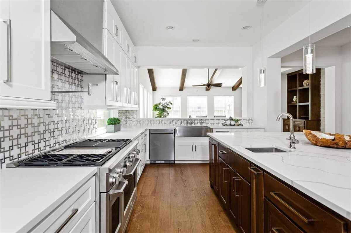 Kitchen connects to the living area, showcasing a spacious design with exposed beams and natural light.