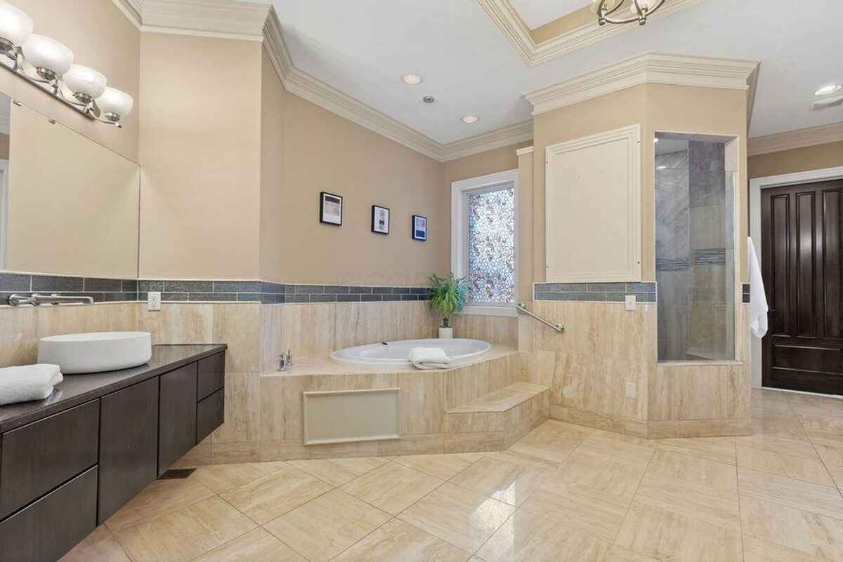 Spacious bathroom with a soaking tub, walk-in shower, and dual vanities adorned with modern fixtures.