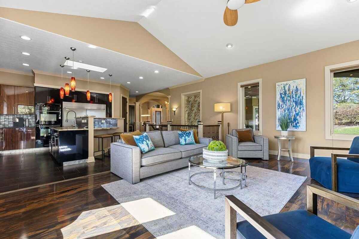 Spacious living area connects seamlessly to the kitchen, offering a view of the dining area and high ceilings for an airy atmosphere.