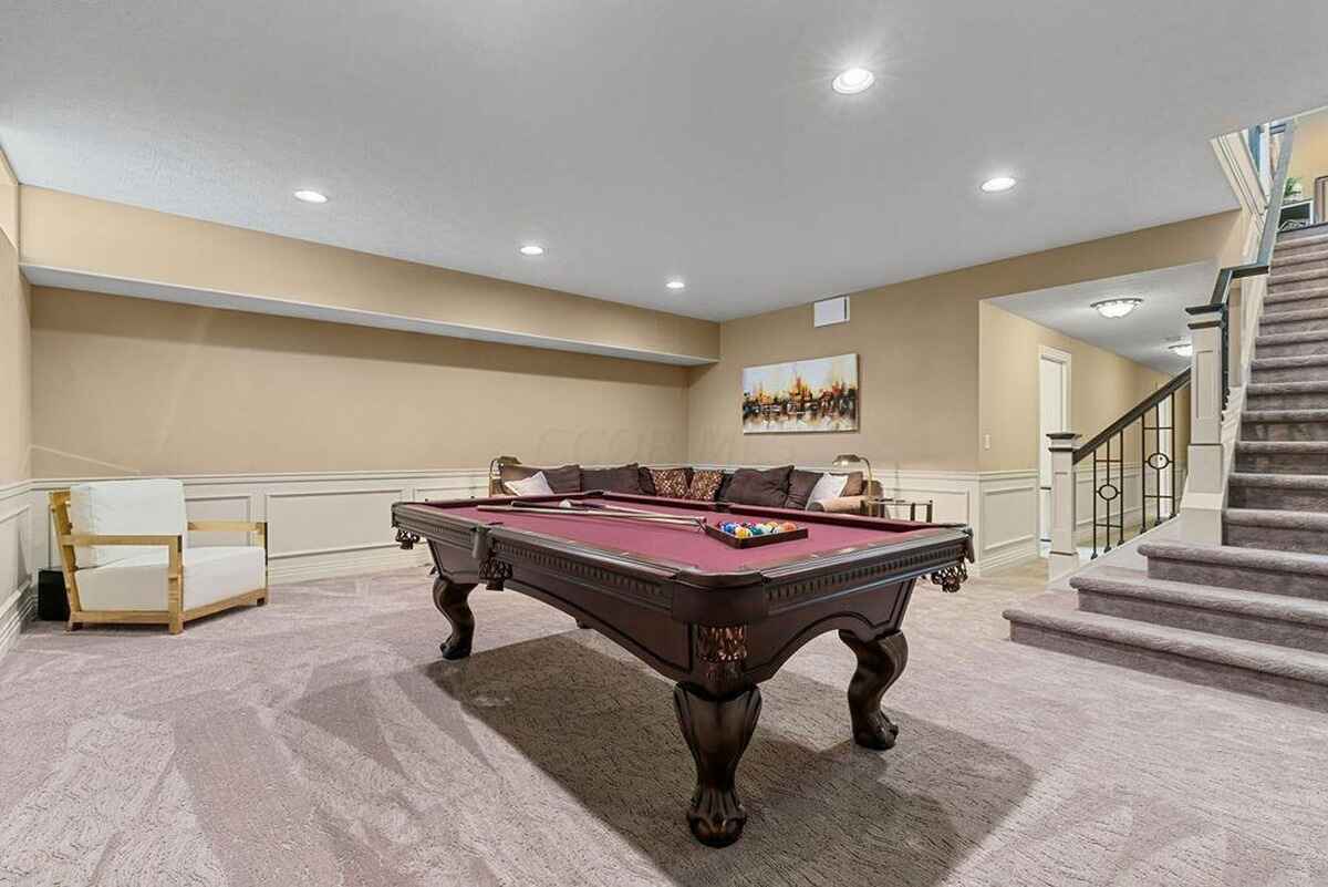 Basement recreation room highlights a pool table, soft carpeting, recessed lighting, and a comfortable seating area.