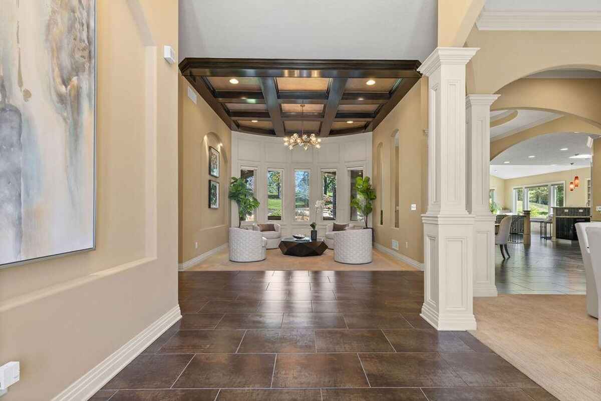 Entry hallway features high ceilings, elegant chandeliers, and open views into the living areas.