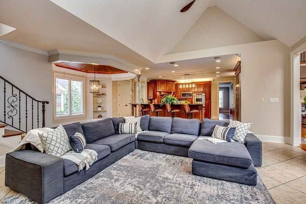 iving room with vaulted ceiling, sectional sofa, and open layout connecting to the kitchen.