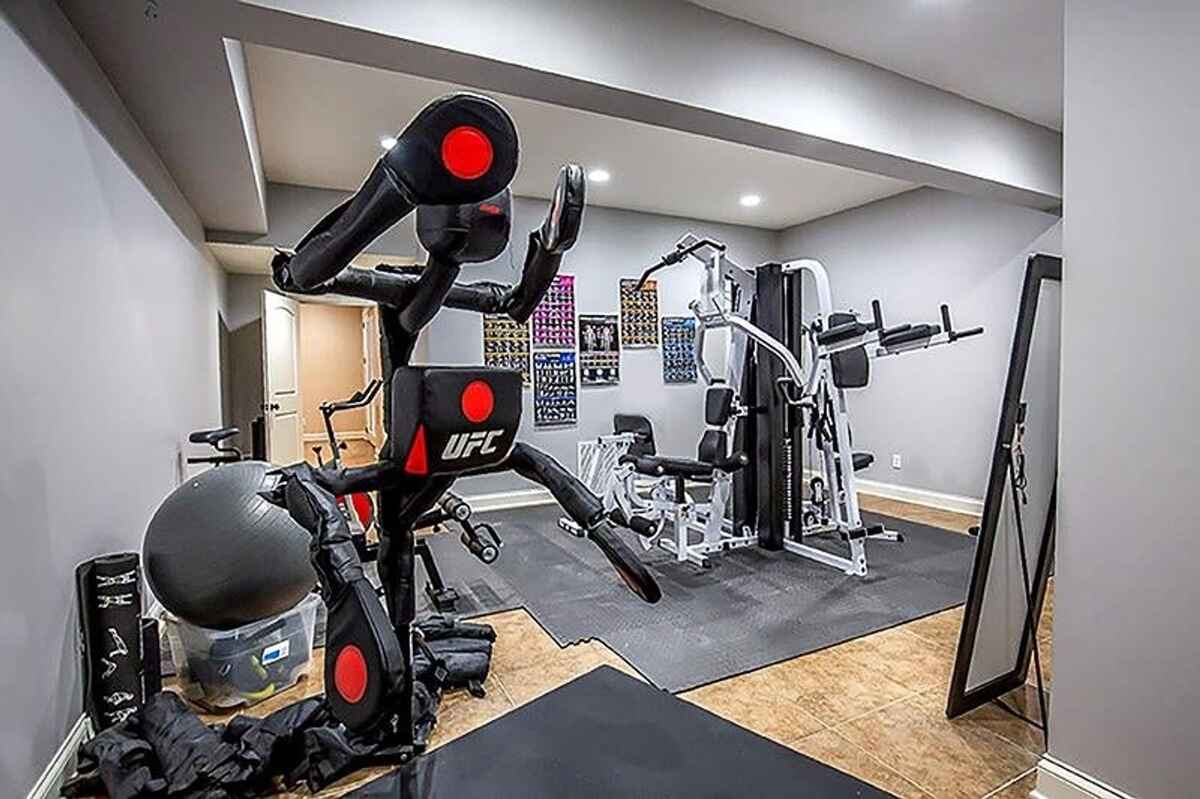 Home gym equipped with fitness machines, free weights, and rubber flooring.