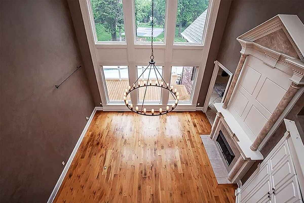 Overhead view of the living room with hardwood floors, chandelier, and fireplace.