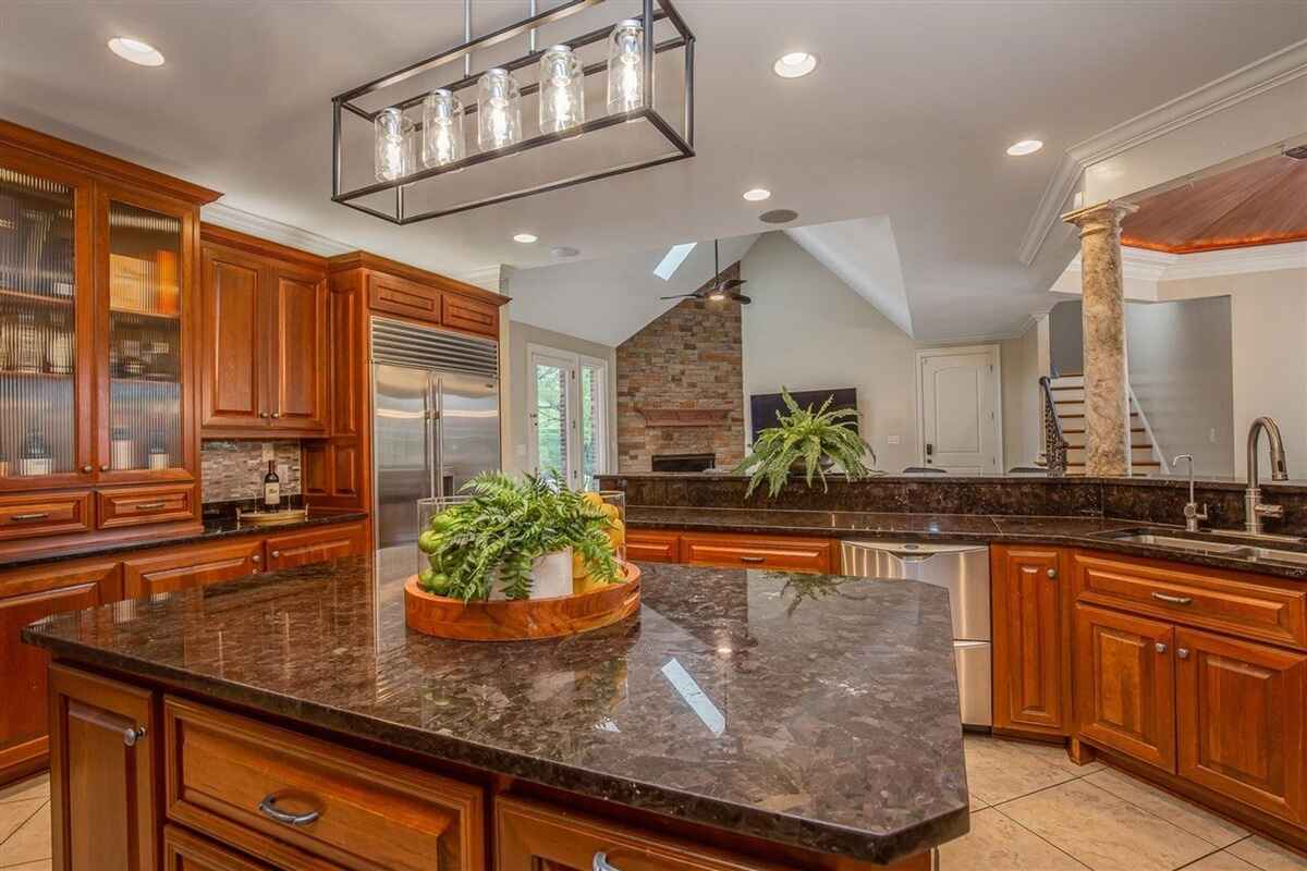 Alternate view of the kitchen showcasing a brick accent wall, built-in appliances, and additional counter space.