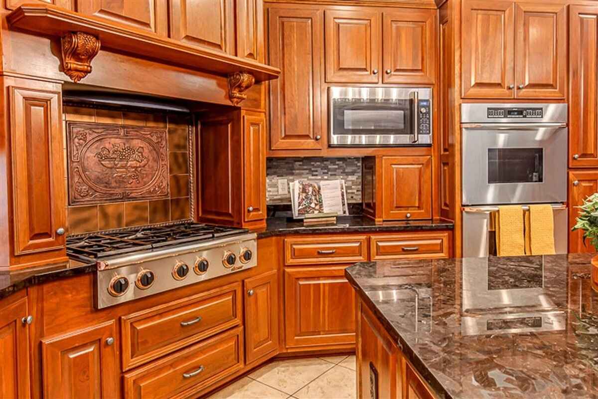 Cooking area with a six-burner stove, a copper backsplash, and stainless steel built-in appliances.