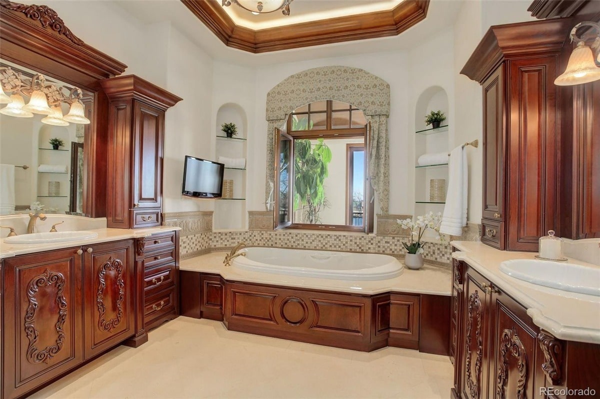 High-end finishes and meticulous craftsmanship are evident throughout this spacious bathroom. The combination of a large soaking tub, custom cabinetry, and natural light creates a luxurious and inviting atmosphere.