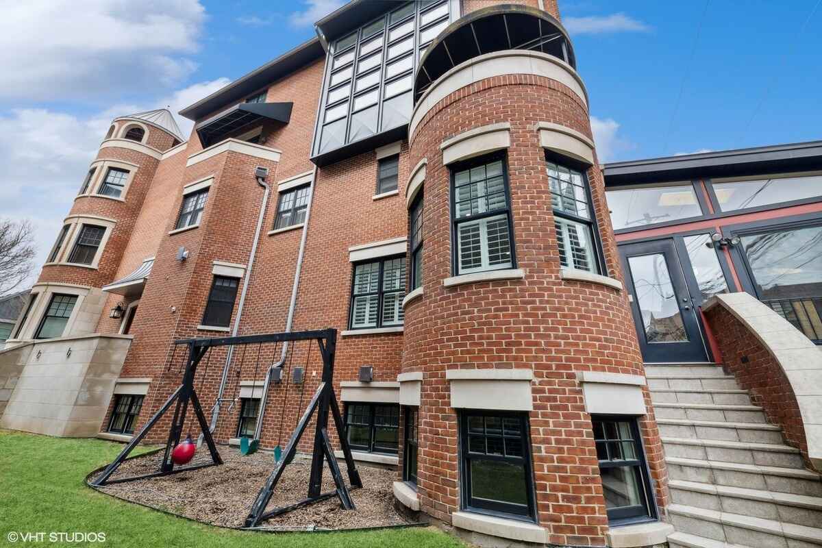 Rear view showcasing the backyard, swing set, and architectural details.